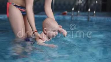 这个小<strong>婴儿</strong>和他妈妈一起在<strong>游泳</strong>池里<strong>游泳</strong>。